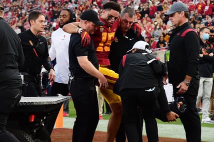 Oct 30, 2021; Los Angeles, California, USA; Southern California Trojans wide receiver Drake London (15) is helped off the field after suffering an injury against the Arizona Wildcats during the first half at United Airlines Field at Los Angeles Memorial Coliseum. Mandatory Credit: Gary A. Vasquez-USA TODAY Sports