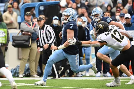 Nov 6, 2021; Chapel Hill, North Carolina, USA; North Carolina Tar Heels quarterback Sam Howell (7) runs as Wake Forest Demon Deacons defensive back Luke Masterson (12) defends in the first quarter at Kenan Memorial Stadium. Mandatory Credit: Bob Donnan-USA TODAY Sports