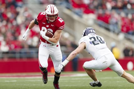 Nov 13, 2021; Madison, Wisconsin, USA;  Wisconsin Badgers tight end Jack Eschenbach (82) rushes with the football as Northwestern Wildcats linebacker Chris Bergin (28) defends during the second quarter at Camp Randall Stadium. Mandatory Credit: Jeff Hanisch-USA TODAY Sports