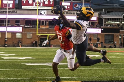 Nov 20, 2021; College Park, Maryland, USA; Michigan Wolverines wide receiver Mike Sainristil (5) catches a one handed touchdown as Maryland Terrapins defensive back Tarheeb Still (12) defends during the first half at Capital One Field at Maryland Stadium. Mandatory Credit: Tommy Gilligan-USA TODAY Sports