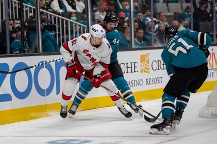 Nov 22, 2021; San Jose, California, USA;  San Jose Sharks defenseman Marc-Edouard Vlasic (44) and defenseman Radim Simek (51) battle for the puck against Carolina Hurricanes center Jesperi Kotkaniemi (82) behind the net during the first period at SAP Center at San Jose. Mandatory Credit: Neville E. Guard-USA TODAY Sports