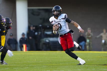 Nov 26, 2021; Greenville, North Carolina, USA;  Cincinnati Bearcats quarterback Desmond Ridder (9) runs with the ball during the first half against the East Carolina Pirates at Dowdy-Ficklen Stadium. Mandatory Credit: James Guillory-USA TODAY Sports
