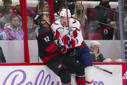 Nov 28, 2021; Raleigh, North Carolina, USA;  Washington Capitals right wing Tom Wilson (43) checks Carolina Hurricanes center Jesperi Kotkaniemi (82) during the first period at PNC Arena. Mandatory Credit: James Guillory-USA TODAY Sports