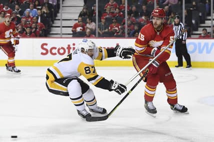 Nov 29, 2021; Calgary, Alberta, CAN; Calgary Flames defenseman Noah Hanifin (55) defends against Pittsburgh Penguins forward Sidney Crosby (87) during the second period at Scotiabank Saddledome. Mandatory Credit: Candice Ward-USA TODAY Sports