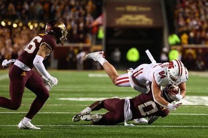 Nov 27, 2021; Minneapolis, Minnesota, USA; Wisconsin Badgers tight end Jake Ferguson (84) runs the ball as Minnesota Gophers defensive back Justin Walley (0) tackles him during the fourth quarter  at Huntington Bank Stadium. Mandatory Credit: Harrison Barden-USA TODAY Sports
