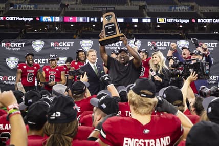 Dec 4, 2021; Detroit, MI, USA; Northern Illinois Huskies head coach Thomas Hammock holds up the trophy with his team after winning the MAC Championship Game against the Kent State Golden Flashes at Ford Field. Mandatory Credit: Raj Mehta-USA TODAY Sports