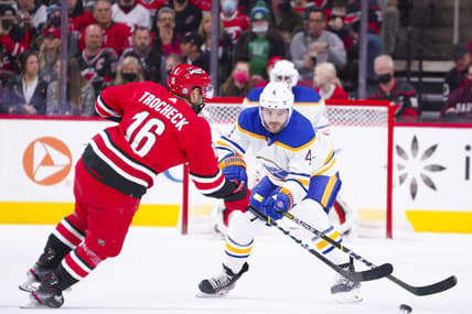 Dec 4, 2021; Raleigh, North Carolina, USA;  Buffalo Sabres defenseman Will Butcher (4) defends against Carolina Hurricanes center Vincent Trocheck (16) during the first period at PNC Arena. Mandatory Credit: James Guillory-USA TODAY Sports