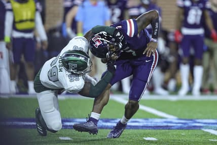 Dec 18, 2021; Mobile, Alabama, USA; Liberty Flames quarterback Malik Willis (7) is pressured by Eastern Michigan Eagles defensive lineman Turan Rush (99) in the first quarter during the 2021 LendingTree Bowl at Hancock Whitney Stadium. Mandatory Credit: Robert McDuffie-USA TODAY Sports