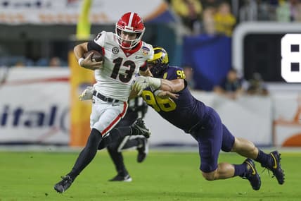 Dec 31, 2021; Miami Gardens, Florida, USA; Georgia Bulldogs quarterback Stetson Bennett (13) runs with the ball ahead of Michigan Wolverines defensive lineman Julius Welschof (96) in the second quarter during the Orange Bowl college football CFP national semifinal game at Hard Rock Stadium. Mandatory Credit: Sam Navarro-USA TODAY Sports