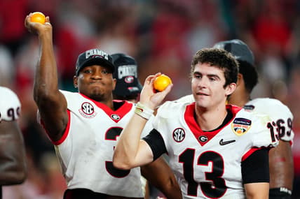 Dec 31, 2021; Miami Gardens, FL, USA; Georgia Bulldogs quarterback Stetson Bennett (13) and running back Zamir White (3) throw oranges after defeating the Michigan Wolverines in the Orange Bowl college football CFP national semifinal game at Hard Rock Stadium. Mandatory Credit: John David Mercer-USA TODAY Sports