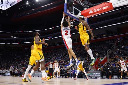Jan 10, 2022; Detroit, Michigan, USA; Detroit Pistons guard Cade Cunningham (2) dunks on Utah Jazz guard Jordan Clarkson (00) in the first half at Little Caesars Arena. Mandatory Credit: Rick Osentoski-USA TODAY Sports