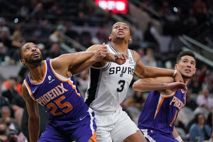 Jan 17, 2022; San Antonio, Texas, USA;  San Antonio Spurs forward Keldon Johnson (3) fights for position against Phoenix Suns forward Mikal Bridges (25) and guard Devin Booker (1) at the AT&T Center. Mandatory Credit: Daniel Dunn-USA TODAY Sports