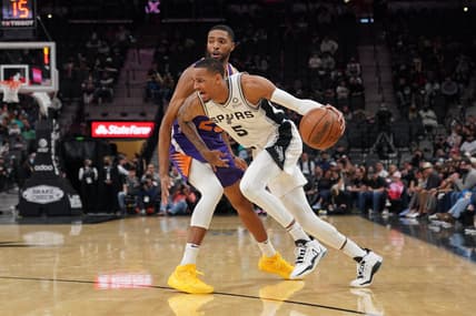 Jan 17, 2022; San Antonio, Texas, USA;  San Antonio Spurs guard Dejounte Murray (5) dribbles past Phoenix Suns forward Mikal Bridges (25) in the second half at the AT&T Center. Mandatory Credit: Daniel Dunn-USA TODAY Sports