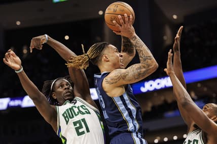 Jan 19, 2022; Milwaukee, Wisconsin, USA; Memphis Grizzlies forward Brandon Clarke (15) shoots between Milwaukee Bucks guard Jrue Holiday (21) and forward Khris Middleton (22) during the second quarter at Fiserv Forum. Mandatory Credit: Jeff Hanisch-USA TODAY Sports