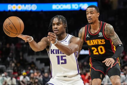 Jan 26, 2022; Atlanta, Georgia, USA; Sacramento Kings guard Davion Mitchell (15) passes the ball behind Atlanta Hawks forward John Collins (20) during the first half at State Farm Arena. Mandatory Credit: Dale Zanine-USA TODAY Sports