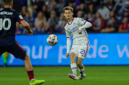 Oct 20, 2021; Cincinnati, OH, USA; FC Cincinnati midfielder Kyle Scott (21) kicks the ball against Chicago Fire FC midfielder Alvaro Medran (10) in the second half at TQL Stadium. Mandatory Credit: Katie Stratman-USA TODAY Sports