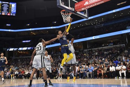 Dec 31, 2021; Memphis, Tennessee, USA; Memphis Grizzlies guard Ja Morant (12) goes to the basket against San Antonio Spurs forward Thaddeus Young (30) during the second half at FedExForum. Mandatory Credit: Justin Ford-USA TODAY Sports