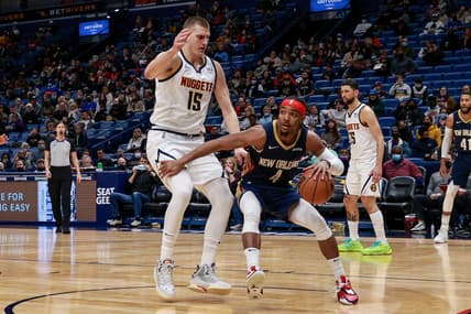 Jan 28, 2022; New Orleans, Louisiana, USA;  New Orleans Pelicans guard Devonte' Graham (4) dribbles around Denver Nuggets center Nikola Jokic (15) during the second half at the Smoothie King Center. Mandatory Credit: Stephen Lew-USA TODAY Sports