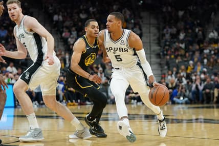 Feb 1, 2022; San Antonio, Texas, USA;  San Antonio Spurs guard Dejounte Murray (5) dribbles past Golden State Warriors guard Jordan Poole (3) in the first half at the AT&T Center. Mandatory Credit: Daniel Dunn-USA TODAY Sports