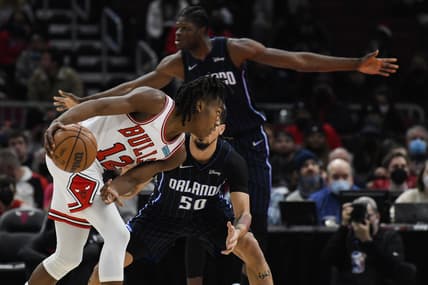 Feb 1, 2022; Chicago, Illinois, USA; Chicago Bulls guard Ayo Dosunmu (12) moves to the basket against Orlando Magic guard Cole Anthony (50) and center Mo Bamba (5), back,  during the first half at the United Center. Mandatory Credit: Matt Marton-USA TODAY Sports