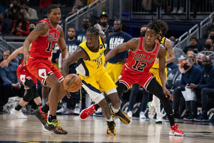 Feb 4, 2022; Indianapolis, Indiana, USA; Indiana Pacers guard Caris LeVert (22) dribbles the ball while Chicago Bulls guard Ayo Dosunmu (12) defends  in the second half at Gainbridge Fieldhouse. Mandatory Credit: Trevor Ruszkowski-USA TODAY Sports
