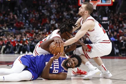 Feb 6, 2022; Chicago, Illinois, USA; Chicago Bulls guard Ayo Dosunmu (12) and guard Matt Thomas (21) defend against Philadelphia 76ers center Joel Embiid (21) during the second half at United Center. Mandatory Credit: Kamil Krzaczynski-USA TODAY Sports