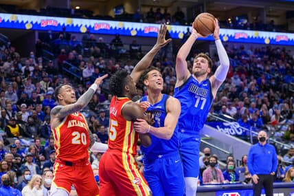 Feb 6, 2022; Dallas, Texas, USA; Dallas Mavericks guard Luka Doncic (77) shoots over Atlanta Hawks forward John Collins (20) and center Clint Capela (15) during the first quarter at the American Airlines Center. Mandatory Credit: Jerome Miron-USA TODAY Sports