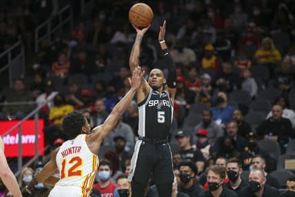 Feb 11, 2022; Atlanta, Georgia, USA; San Antonio Spurs guard Dejounte Murray (5) shoots over Atlanta Hawks forward De'Andre Hunter (12) in the first quarter at State Farm Arena. Mandatory Credit: Brett Davis-USA TODAY Sports