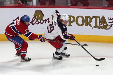 Feb 12, 2022; Montreal, Quebec, CAN; Columbus Blue Jackets left wing Patrik Laine (29) plays the puck against Montreal Canadiens right wing Josh Anderson (17) during the first period at Bell Centre. Mandatory Credit: Jean-Yves Ahern-USA TODAY Sports