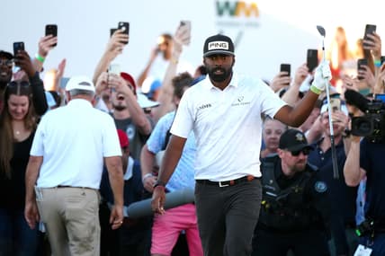 Feb 12, 2022; Scottsdale Arizona, USA; Sahith Theegala raises his club after chipping from the rough in the crowd on the 18th hole during Round 3 at the WM Phoenix Open. Mandatory Credit: Patrick Breen-USA TODAY Sports