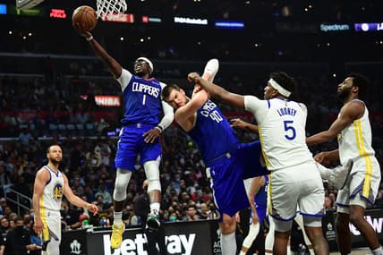 Feb 14, 2022; Los Angeles, California, USA; Los Angeles Clippers guard Reggie Jackson (1) moves to the basket as center Ivica Zubac (40) provides coverage against Golden State Warriors center Kevon Looney (5) during the first half at Crypto.com Arena. Mandatory Credit: Gary A. Vasquez-USA TODAY Sports