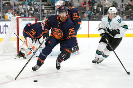 Feb 14, 2022; San Jose, California, USA; Edmonton Oilers defenseman Darnell Nurse (25) skates with the puck while being pursued by San Jose Sharks left wing Alexander Barabanov (94) during the second period at SAP Center at San Jose. Mandatory Credit: Darren Yamashita-USA TODAY Sports