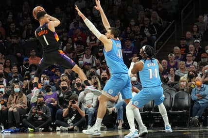 Feb 15, 2022; Phoenix, Arizona, USA; LA Clippers center Ivica Zubac (40) and LA Clippers guard Terance Mann (14) guard Phoenix Suns guard Devin Booker (1) during the first half at Footprint Center. Mandatory Credit: Joe Camporeale-USA TODAY Sports