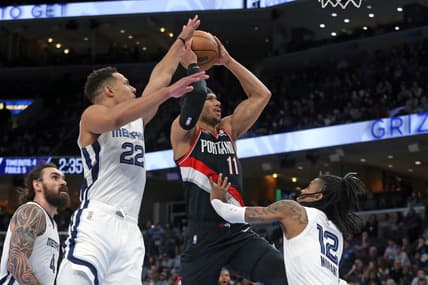 Feb 16, 2022; Memphis, Tennessee, USA; Portland Trail Blazers guard Josh Hart (11) drives to the basket as Memphis Grizzles guard Desmond Bane (22) and guard Ja Morant (12) defend during the first half at FedExForum. Mandatory Credit: Petre Thomas-USA TODAY Sports