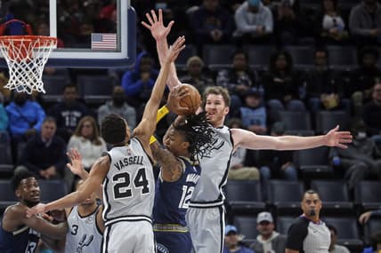 Feb 28, 2022; Memphis, Tennessee, USA; Memphis Grizzles guard Ja Morant (12) drives to the basket as San Antonio Spurs guard-forward Devin Vassell (24) and center Jakob Poeltl (25) defend during the first half at FedExForum. Mandatory Credit: Petre Thomas-USA TODAY Sports