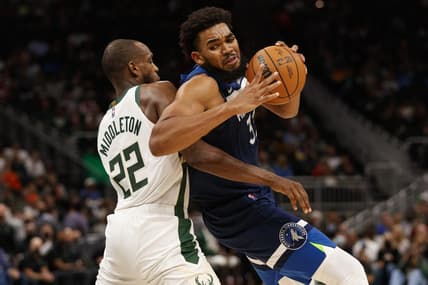 Oct 27, 2021; Milwaukee, Wisconsin, USA;  Minnesota Timberwolves center Karl-Anthony Towns (32) spins towards the basket around Milwaukee Bucks forward Khris Middleton (22) during the second quarter at Fiserv Forum. Mandatory Credit: Jeff Hanisch-USA TODAY Sports