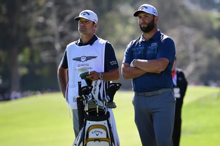 Feb 18, 2022; Pacific Palisades, California, USA; Jon Rahm speaks with caddy Adam Hayes before playing his shot on the eighth fairway during the second round of the Genesis Invitational golf tournament. Mandatory Credit: Gary A. Vasquez-USA TODAY Sports