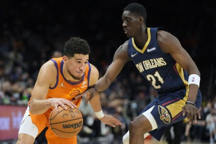 Feb 25, 2022; Phoenix, Arizona, USA; Phoenix Suns guard Devin Booker (1) drives on New Orleans Pelicans forward Tony Snell (21) in the second half at Footprint Center. Mandatory Credit: Rick Scuteri-USA TODAY Sports