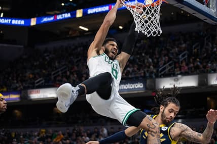 Feb 27, 2022; Indianapolis, Indiana, USA; Boston Celtics forward Jayson Tatum (0) slam dunks the ball and is fouled by Indiana Pacers guard Duane Washington Jr. (4) in the second half at Gainbridge Fieldhouse. Mandatory Credit: Trevor Ruszkowski-USA TODAY Sports