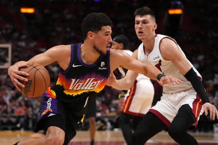 Mar 9, 2022; Miami, Florida, USA; Phoenix Suns guard Devin Booker (1) drives the ball around Miami Heat guard Tyler Herro (14) during the first half at FTX Arena. Mandatory Credit: Jasen Vinlove-USA TODAY Sports