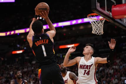 Mar 9, 2022; Miami, Florida, USA; Phoenix Suns guard Devin Booker (1) shoots the ball over Miami Heat guard Tyler Herro (14) during the first half at FTX Arena. Mandatory Credit: Jasen Vinlove-USA TODAY Sports