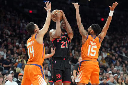 Mar 11, 2022; Phoenix, Arizona, USA; Toronto Raptors forward Thaddeus Young (21) drives against Phoenix Suns guard Landry Shamet (14) and guard Cameron Payne (15) during the first half at Footprint Center. Mandatory Credit: Joe Camporeale-USA TODAY Sports