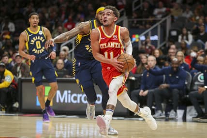 Mar 13, 2022; Atlanta, Georgia, USA; Atlanta Hawks guard Trae Young (11) drives past Indiana Pacers forward Oshae Brissett (12) in the second half at State Farm Arena. Mandatory Credit: Brett Davis-USA TODAY Sports
