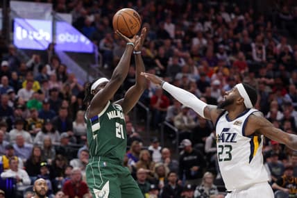 Mar 14, 2022; Salt Lake City, Utah, USA; Milwaukee Bucks guard Jrue Holiday (21) shoots the ball over Utah Jazz forward Royce O'Neale (23) during the second half at Vivint Arena. Milwaukee Bucks won 117-111. Mandatory Credit: Chris Nicoll-USA TODAY Sports