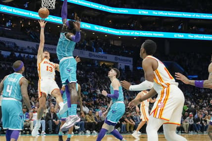 Mar 16, 2022; Charlotte, North Carolina, USA; Atlanta Hawks guard Bogdan Bogdanovic (13) gets off his shot defended by Charlotte Hornets center Montrezl Harrell (8) during the second quarter at the Spectrum Center. Mandatory Credit: Jim Dedmon-USA TODAY Sports