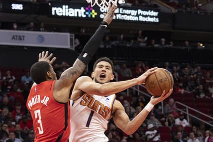 Mar 16, 2022; Houston, Texas, USA; Phoenix Suns guard Devin Booker (1) shoots against Houston Rockets guard Kevin Porter Jr. (3) in the first quarter at Toyota Center. Mandatory Credit: Thomas B. Shea-USA TODAY Sports