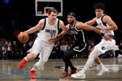 Mar 16, 2022; Brooklyn, New York, USA; Dallas Mavericks guard Luka Doncic (77) drives around Brooklyn Nets forward Bruce Brown (1) in front of Mavericks guard Josh Green (8) during the first quarter at Barclays Center. Mandatory Credit: Brad Penner-USA TODAY Sports