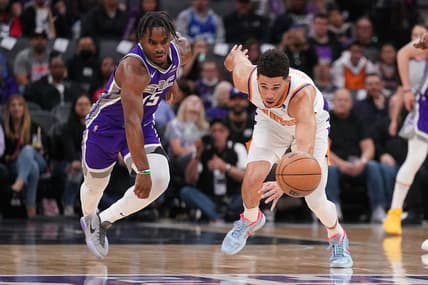 Mar 20, 2022; Sacramento, California, USA; Phoenix Suns guard Devin Booker (1) tracks down a loose ball next to Sacramento Kings guard Davion Mitchell (15) in the first quarter at the Golden 1 Center. Mandatory Credit: Cary Edmondson-USA TODAY Sports