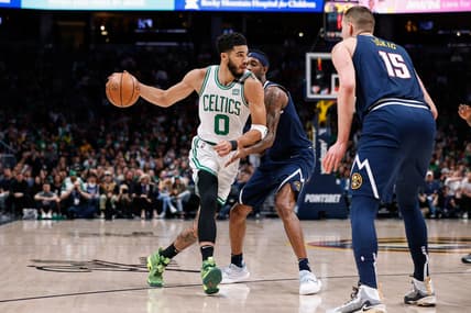 Mar 20, 2022; Denver, Colorado, USA; Boston Celtics forward Jayson Tatum (0) controls the ball against Denver Nuggets forward Will Barton (5) as center Nikola Jokic (15) defends in the first quarter at Ball Arena. Mandatory Credit: Isaiah J. Downing-USA TODAY Sports