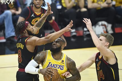 Mar 21, 2022; Cleveland, Ohio, USA; Los Angeles Lakers forward LeBron James (6) drives between Cleveland Cavaliers forward Lamar Stevens (8) and forward Lauri Markkanen (24) in the first quarter at Rocket Mortgage FieldHouse. Mandatory Credit: David Richard-USA TODAY Sports